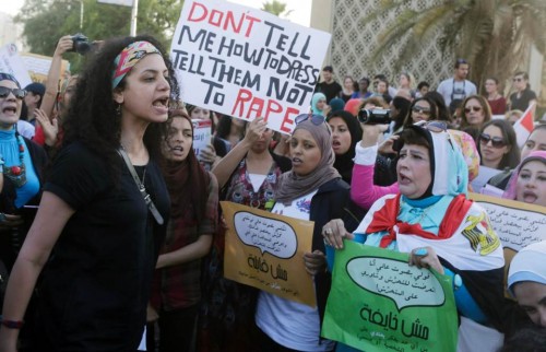 Femme protestant contre le harcèlement sexuel en Egypte,  au Caire, Juin 2014.  Pancarte: "Ne me dites pas comment m'habiller, dites-leur de ne pas violer." 